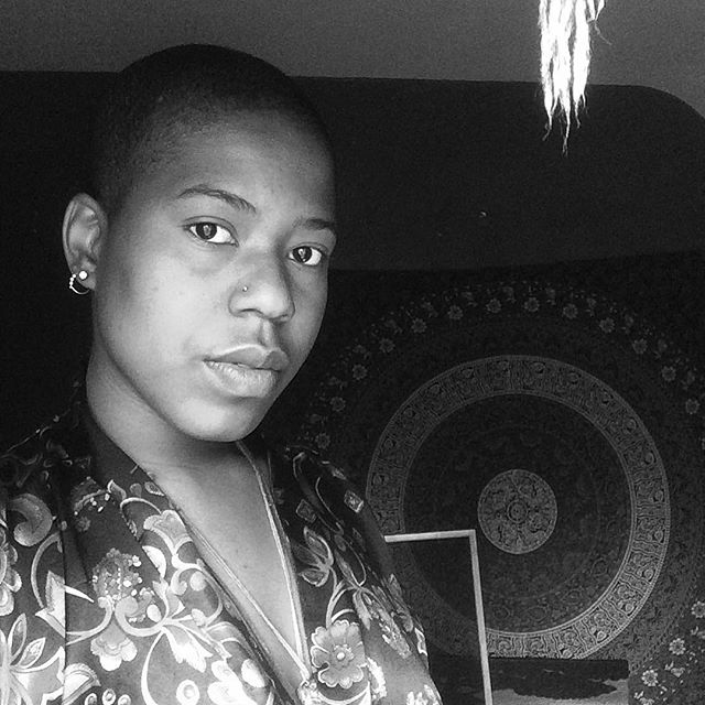 Gaze steady, cloaked in shadow and knowing