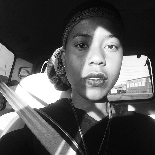 Black and white portrait in a car, light slicing diagonally across the face