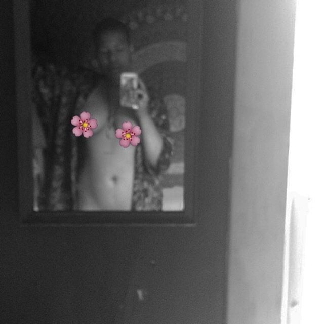 Self portrait in shadowed mirror, body bare and adorned