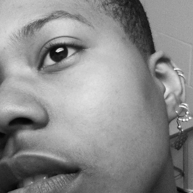 Black and white close-up of eye, lips, and ear with piercings