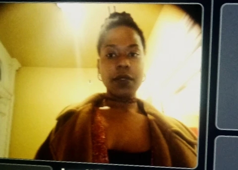 Blurred portrait of a woman in warm tones, standing in golden light, looking forward